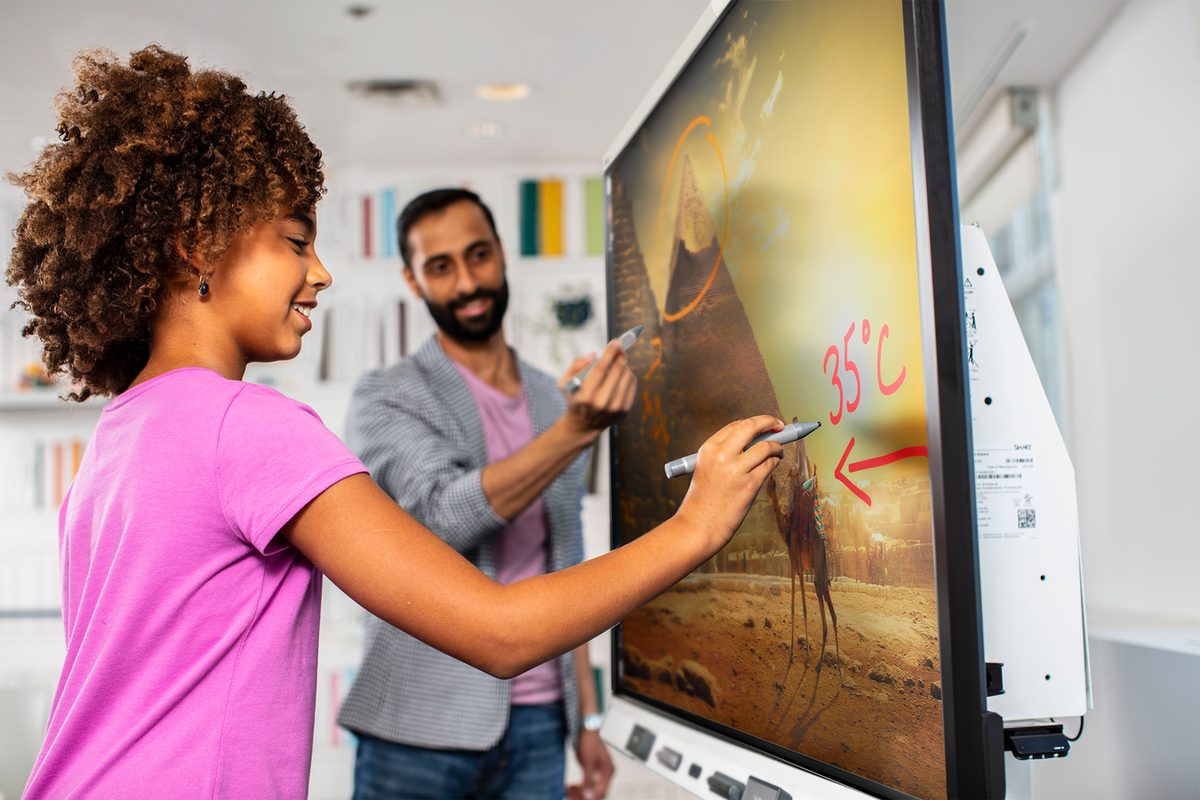 A teacher and student annotating on a SMART Board display